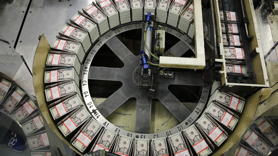 Stacks of $5 bills sit on a circular conveyor belt.