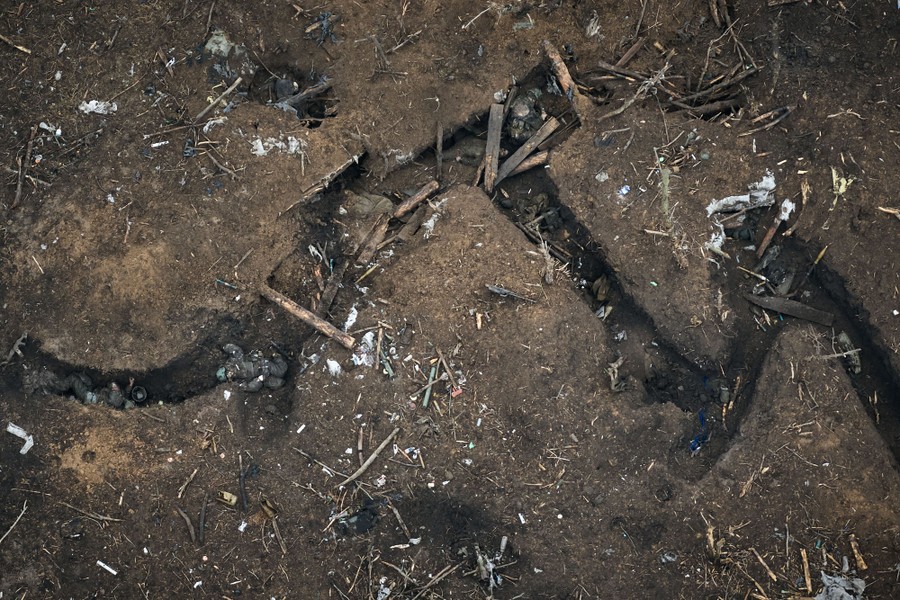 An aerial view of a trench in a battlefield; several dead soldiers are visible