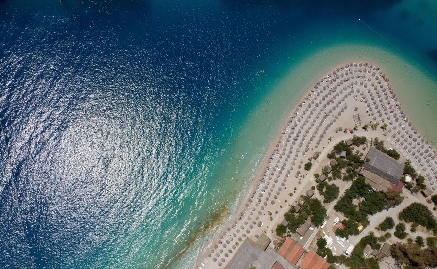 An aerial view of a resort beach and surrounding blue-green water