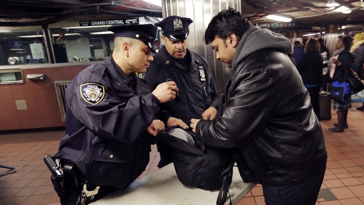Police officers inspect a bag in a New York subway station.