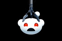 An image of the Reddit logo stuck in a claw