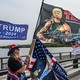People standing on a bridge holding flags in support of Donald Trump