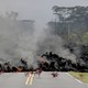 Bundles of leaves lie along a road where lava is moving toward them.