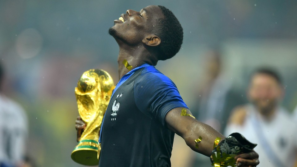 France's Paul Pogba holds the trophy as he celebrates winning the World Cup