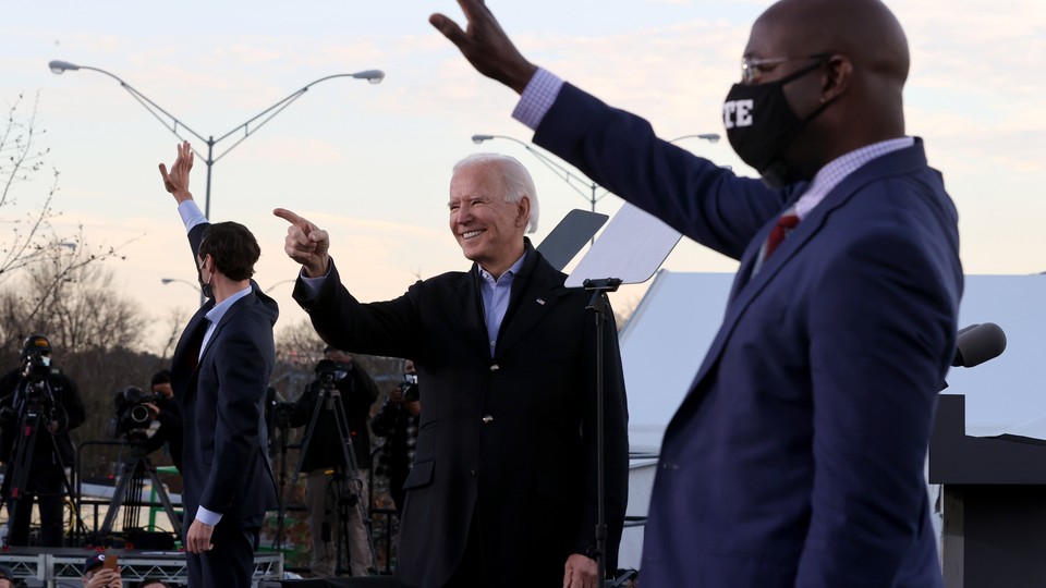 Jon Ossoff, Joe Biden, and Raphael Warnock campaign on a stage in Georgia.