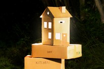 photo of cardboard moving boxes, one of which is shaped like a house