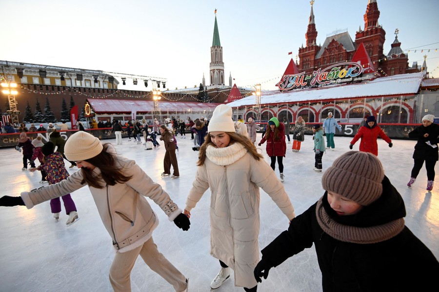 People ice-skate at a public outdoor rink.