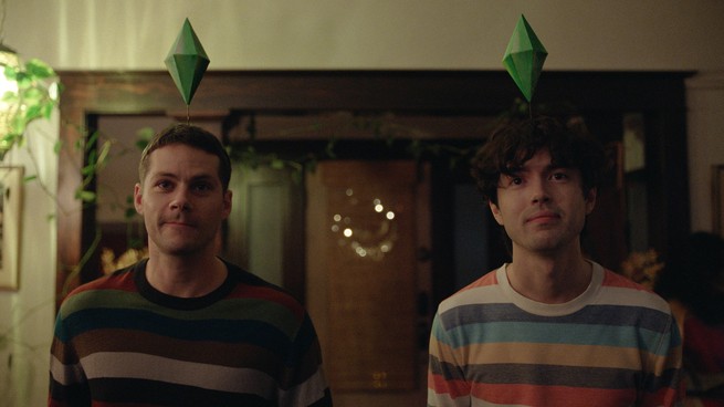 Two young men look forward wearing striped sweaters