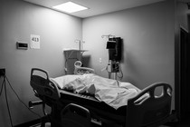 A hospital bed with a deceased patient in a body bag