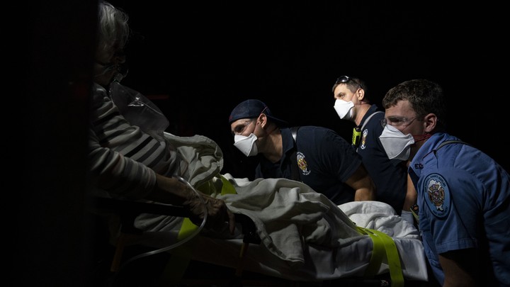Paramedics prepare to transport a coronavirus patient to the hospital.