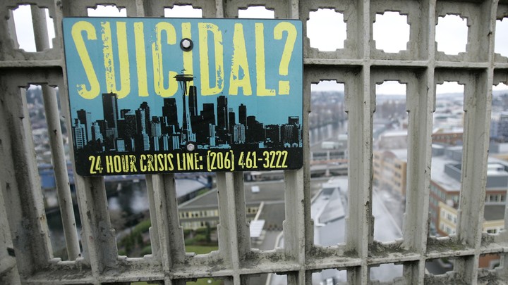 A sign advising of the phone number for a suicide-prevention hotline is shown on the Aurora Bridge in Seattle.