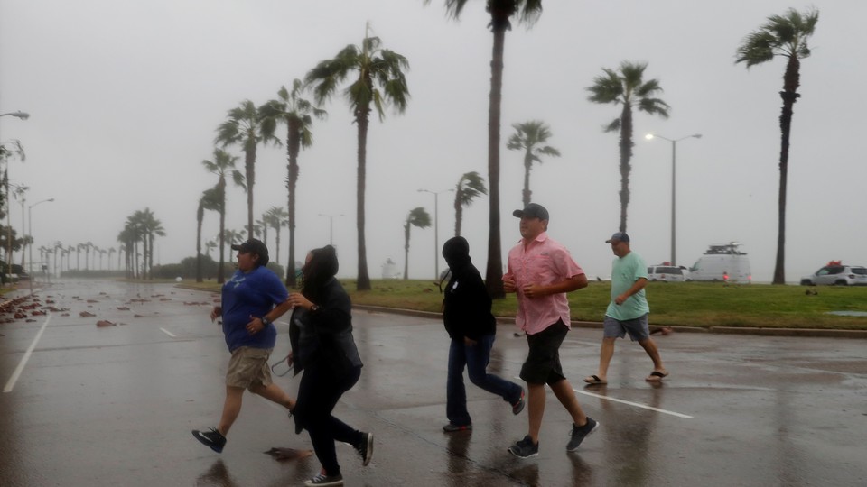 A group races across the street as winds from Hurricane Harvey escalate in Corpus Christi, Texas, on August 25, 2017.