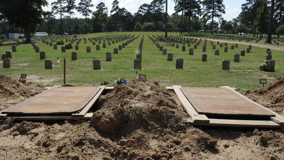 Empty graves at the front of a cemetery