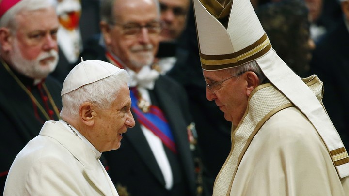 Pope Francis greets Pope Emeritus Benedict XVI.
