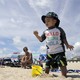 A toddler plays in the sand at the beach.