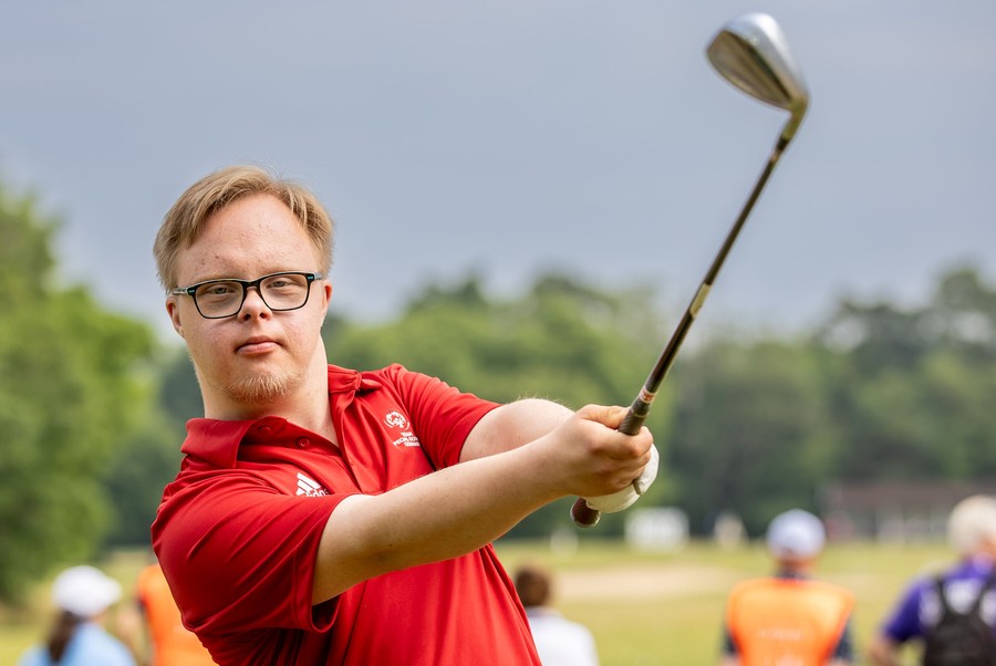A golfer looks downrange after a swing.