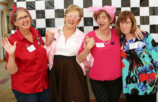 Four women who became friends in retirement pose for a photo.