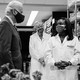 President Joe Biden listens to Kizzmekia Corbett, an immunologist with the Vaccine Research Center at the National Institutes of Health. Antony Fauci stands in the background.