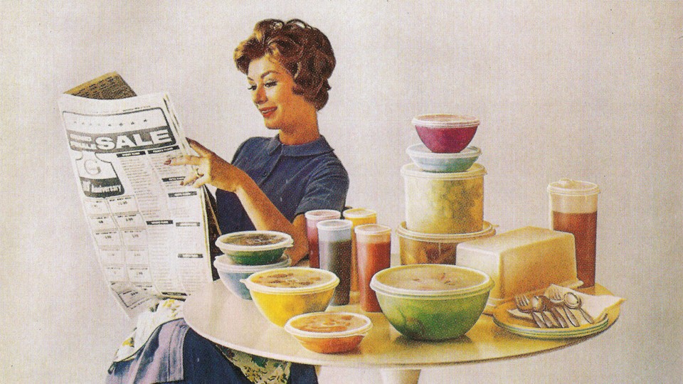 A woman sits at a table with tupperware circa 1960s.