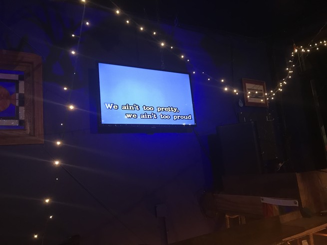 A karaoke screen showing lyrics from Billy Joel's "Only the Good Die Young."