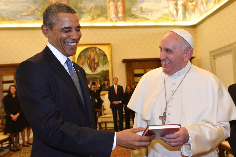 Pope Francis and President Barack Obama smile as they exchange gifts.