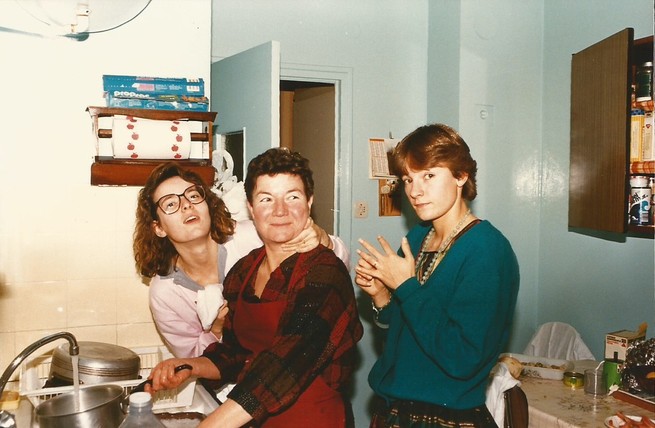 Archival photo of three women standing in kitchen