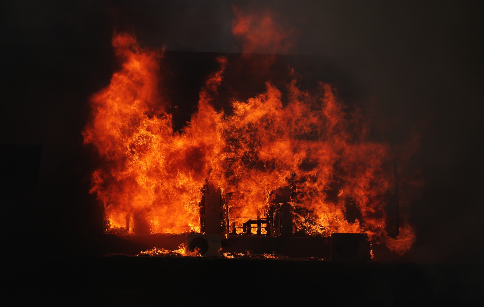 Tall flames rise from a burning presidential palace, seen at night.