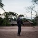 A health worker holds a megaphone to his mouth while standing on a patch of dirt.