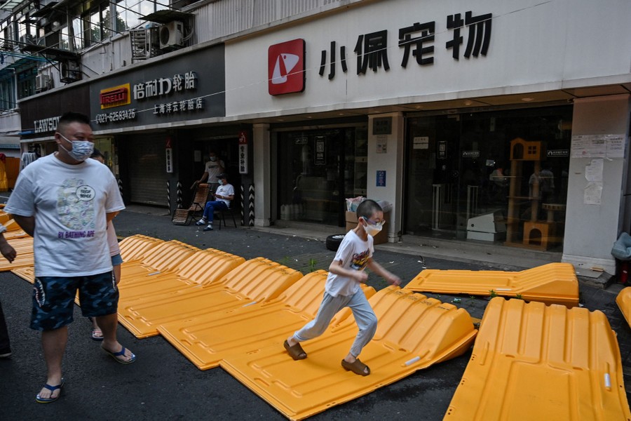 A boy runs over fallen barrier sections.