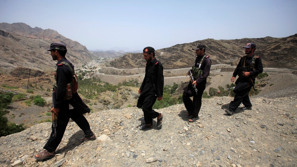 Four Pakistani security personnel patrol the border with Afghanistan