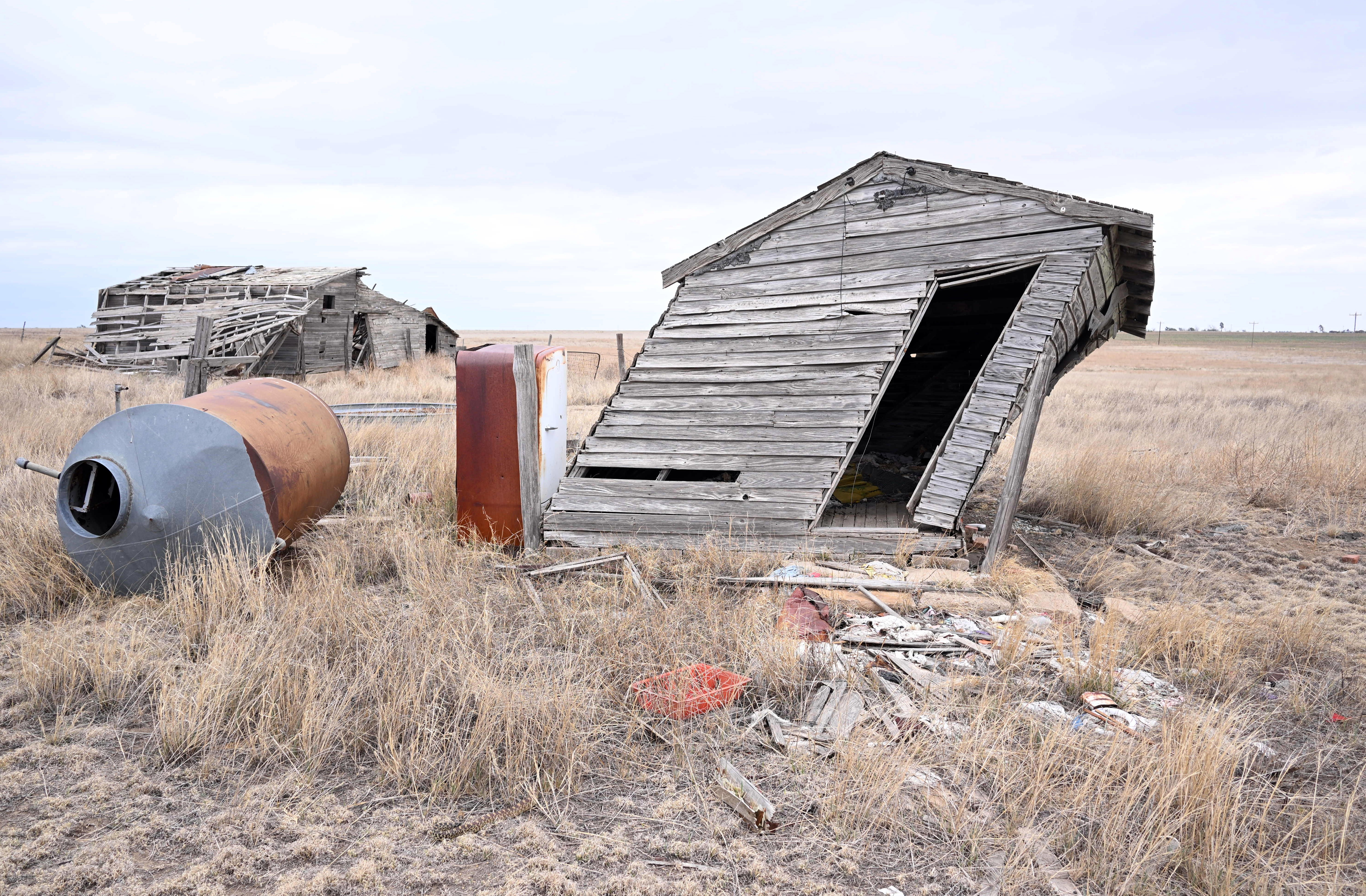A shack leans far to the right on an abandoned homestead.