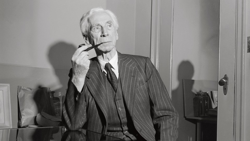 A black-and-white portrait of Bertrand Russell in a three-piece striped suit, smoking a pipe