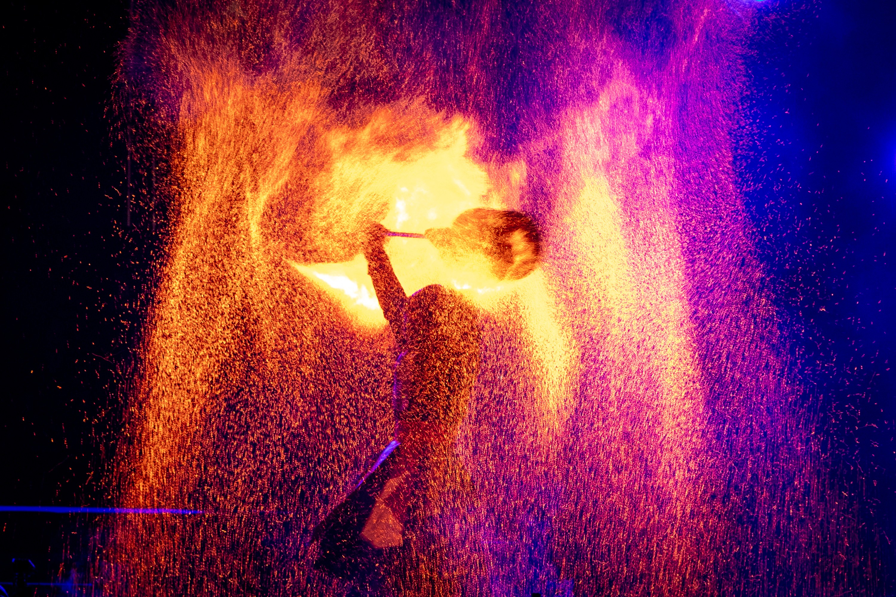 Sparks fly as a performer twirls a flaming object.