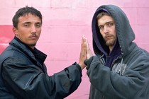 Two strangers touching hands and looking at the camera