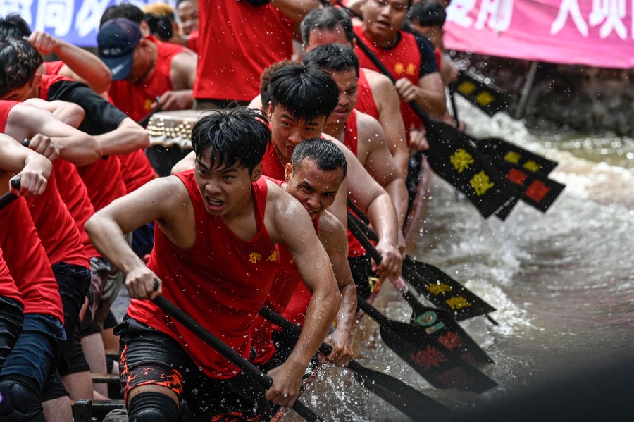 A close view of people in a dragon boat paddling hard during a race