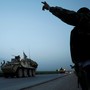 A Kurdish fighter from the People's Protection Units (YPG) gestures at a convoy of U.S military vehicles driving in the town of Darbasiya next to the Turkish border, Syria, on April 28, 2017. 