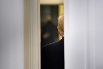 A door cracked open, with Donald Trump's back showing