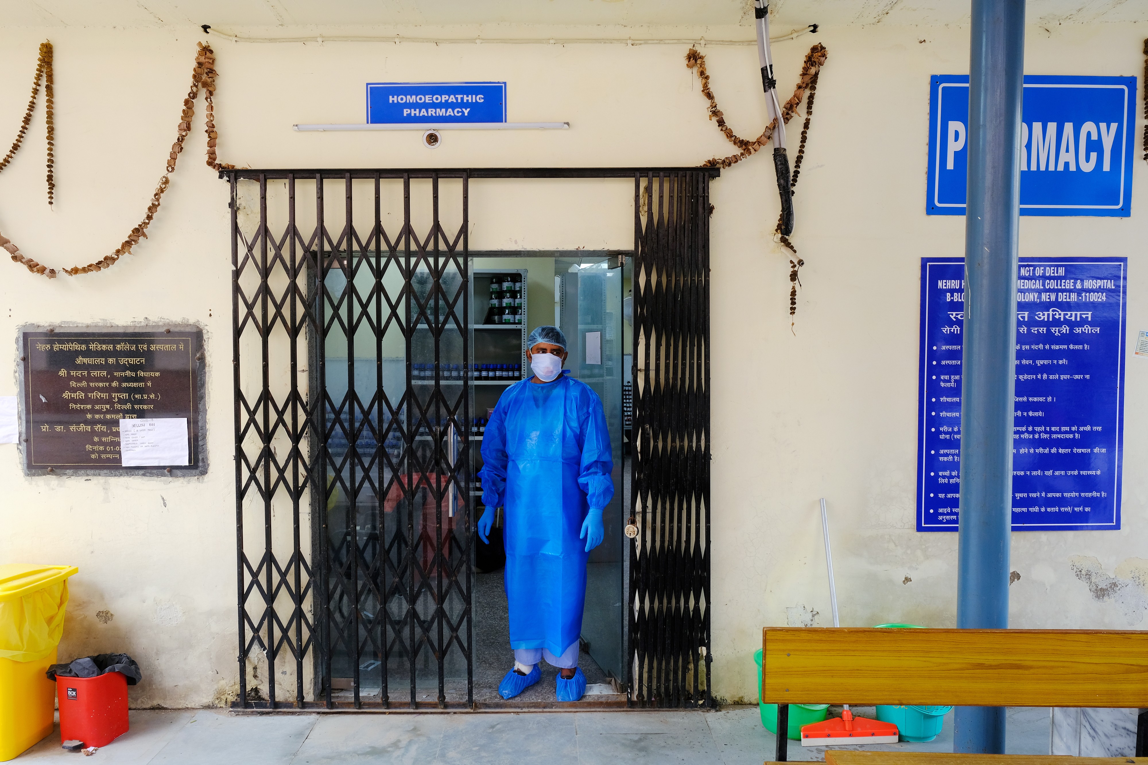 A health worker wearing personal protective equipment stands in a doorway at a COVID-19 testing center.