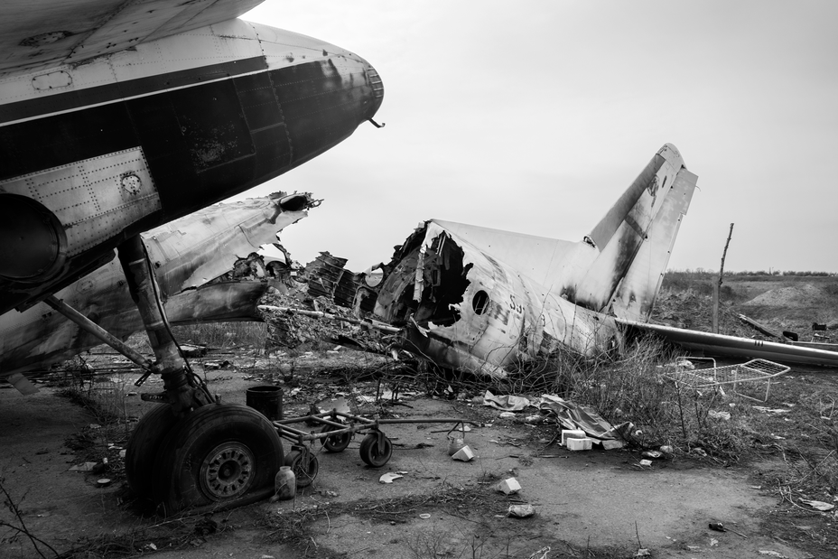 black-and-white photo of destroyed planes on debris-strewn field