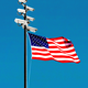 A flagpole with surveillance cameras at the top and an American flag waving