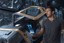 Chris Pratt stands in front of a hibernation pod in the movie Passengers.