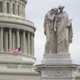 An American flag flies at half staff over the U.S. Capitol and behind the Peace Monument in Washington, D.C.