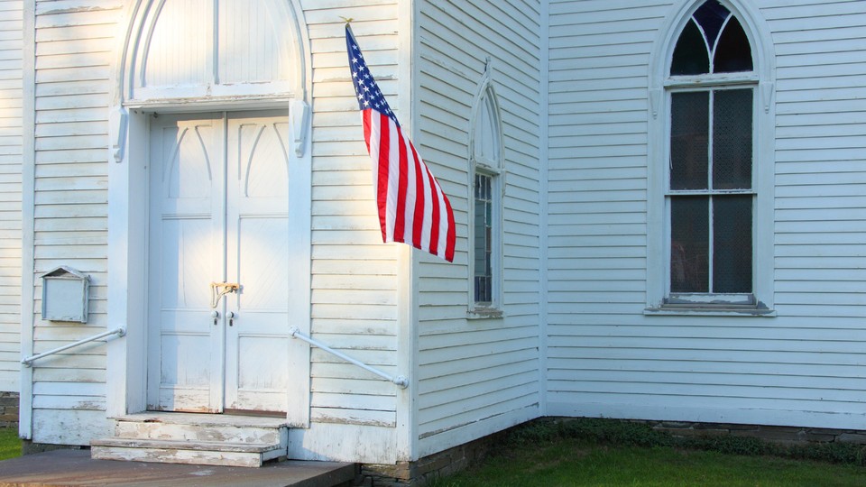 Photograph of a church entrance with an American flag hanging on it