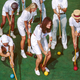 photo of group of croquet players with mallets and balls on green field