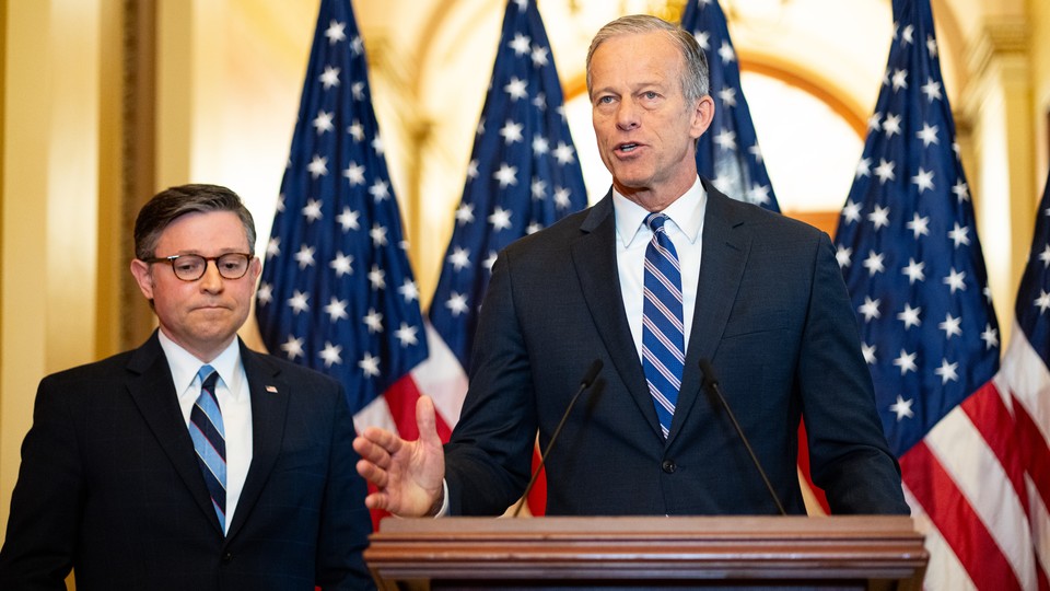 Mike Johnson stands next to a podium