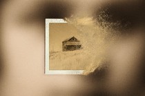 A faded image of a house that's turning into dust, superimposed on a blurry image of a woman's face