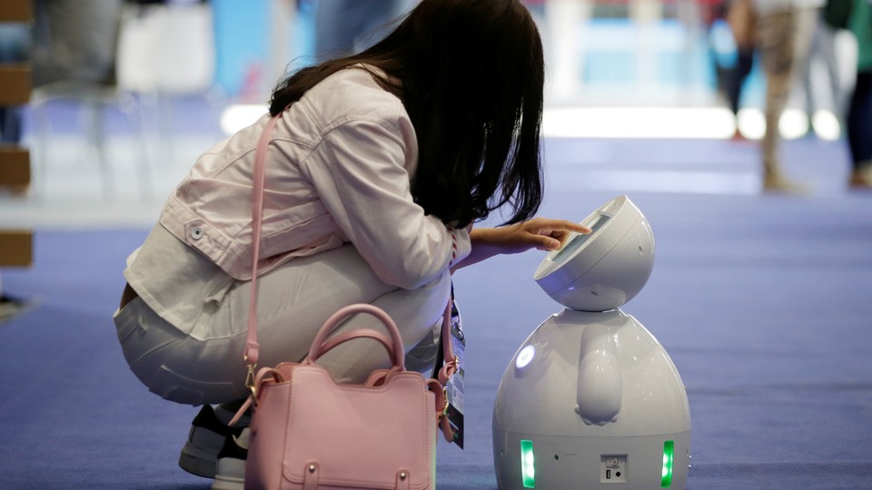 A woman interacts with a small robot.