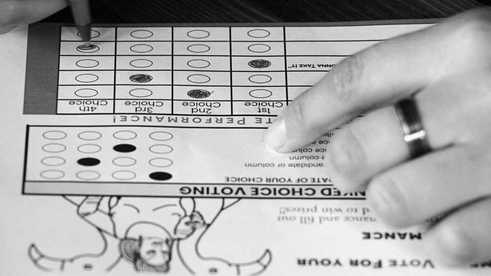 A close-up of a pen being used to fill out bubbles on a ranked-choice-voting ballot