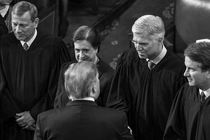 black-and-white photo of Supreme Court justices John Roberts, Elena Kagan, Neil Gorsuch, and Brett Kavanaugh standing in a line, Gorsuch shaking Donald Trump's hand