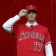 Baseball player Shohei Ohtani poses for photos after a news conference at Angel Stadium